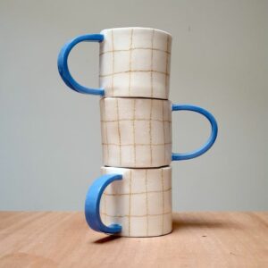 Odeon Studio Karierter Becher mit blauem Henkel